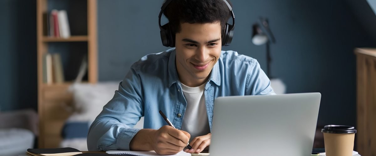 man-is-using-laptop-he-is-wearing-headphones